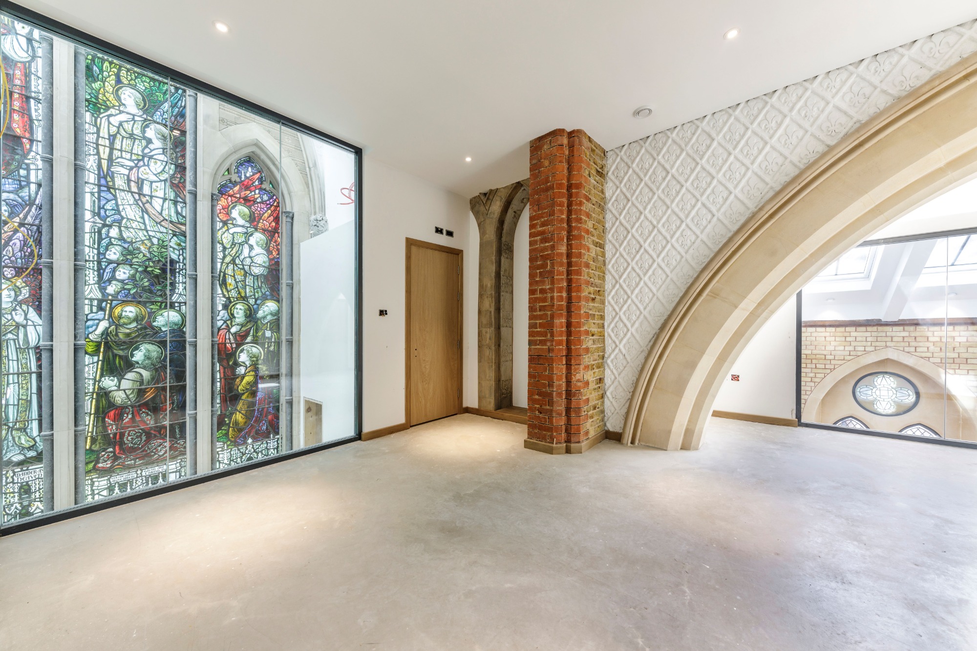 Modern interior featuring stained glass windows and a blend of brick and contemporary design.