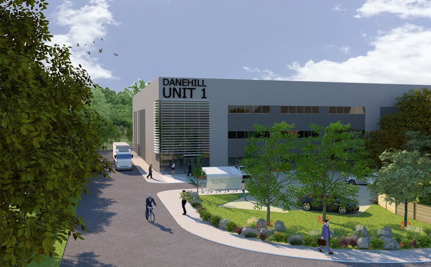 Modern building with large windows, surrounded by greenery and landscaping.