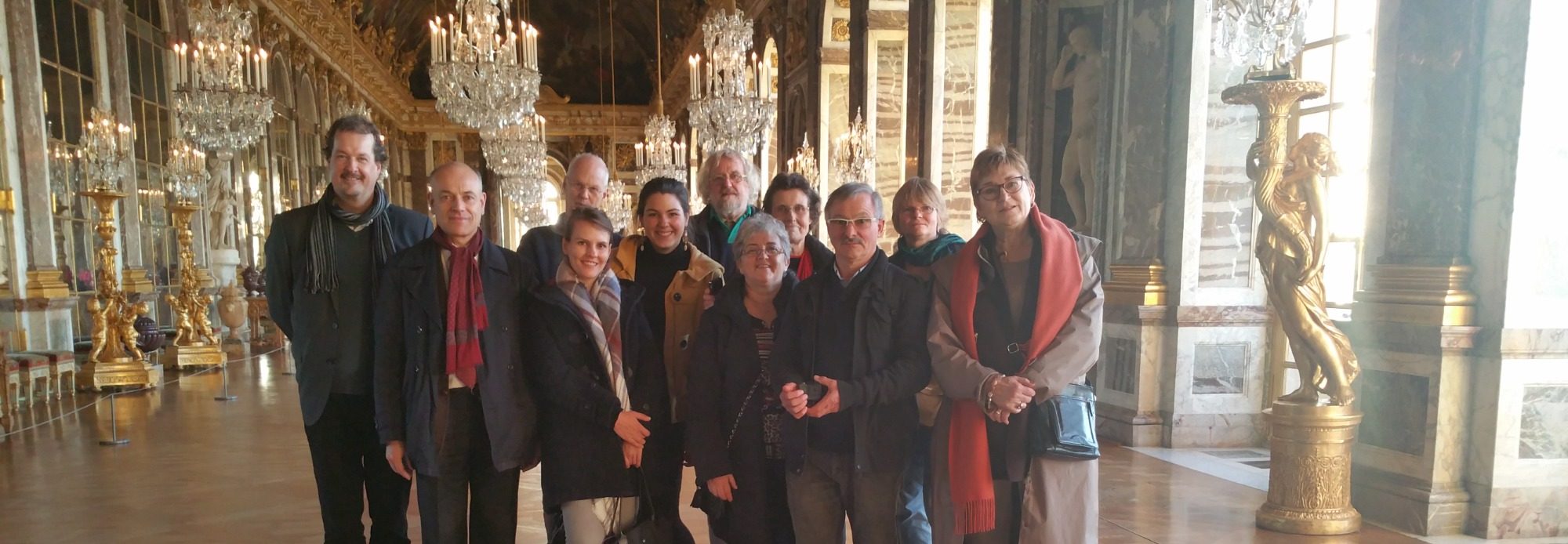 Group of people posing together in an ornate interior space.