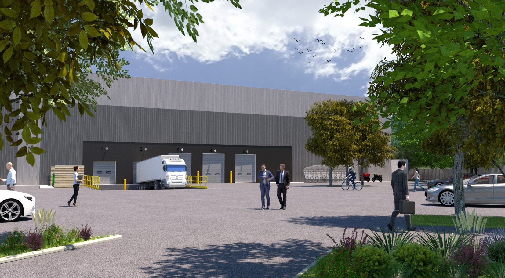 A modern industrial building with people and vehicles in a well-landscaped outdoor area.