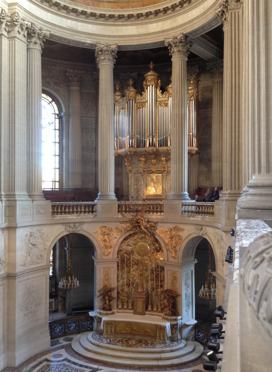 Interior view of a grand church featuring ornate columns and a decorative altar.